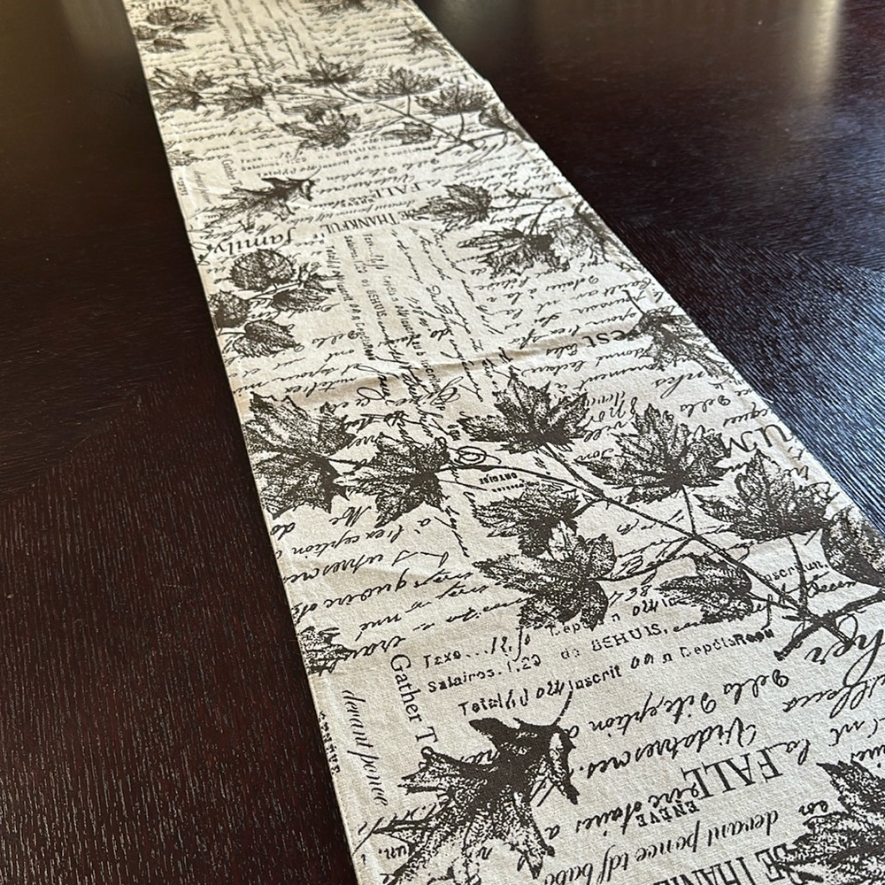 Cream table runner with fall leaves and text pattern